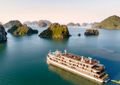 A serene river cruise ship sailing through lush green islands and tranquil waters at sunset.
