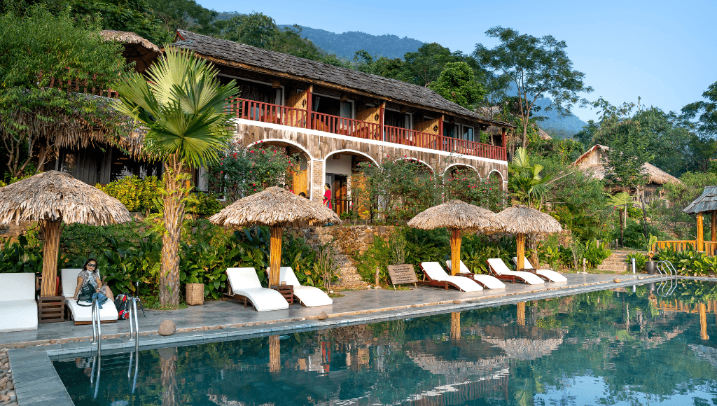 A serene eco-tour resort in Costa Rica, featuring a tranquil pool surrounded by lush greenery and rustic accommodations, perfect for nature-loving travelers.