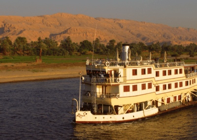 A traditional Nile River cruise in Egypt, with a historic riverboat and arid desert landscapes in the distance.