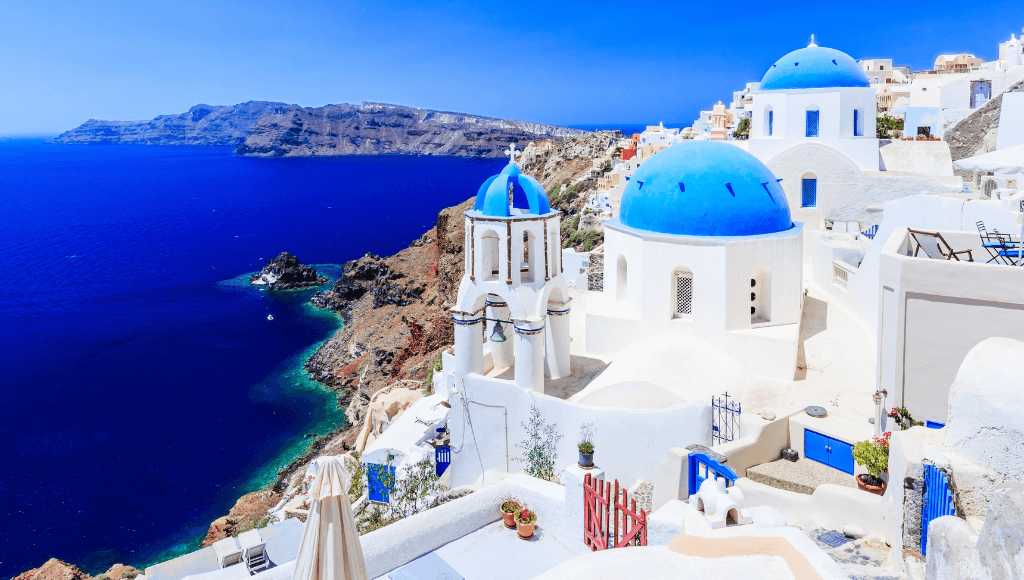 Iconic blue-domed churches overlooking the Aegean Sea in Santorini, Greece.